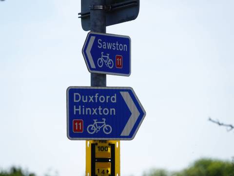 Photograph of two National Cycle Route direction signs. The top sign points to Sawston, the bottom sign points to Duxford and Hinxton.