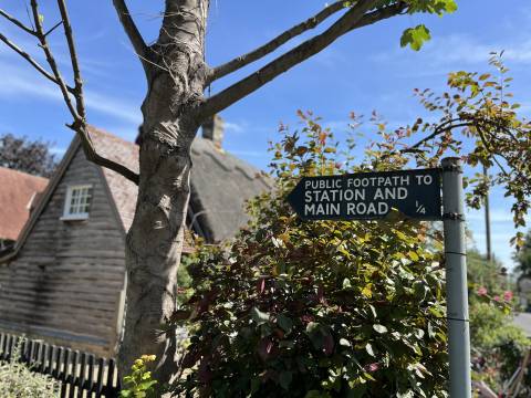 A photograph of a footpath sign in Foxton pointing to the Station and Main Road.