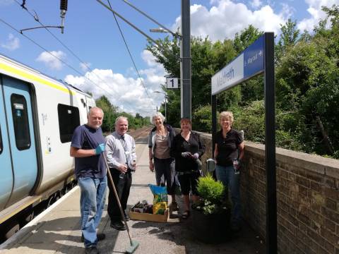Photograph of a group of gardeners on the platform at Meldreth station