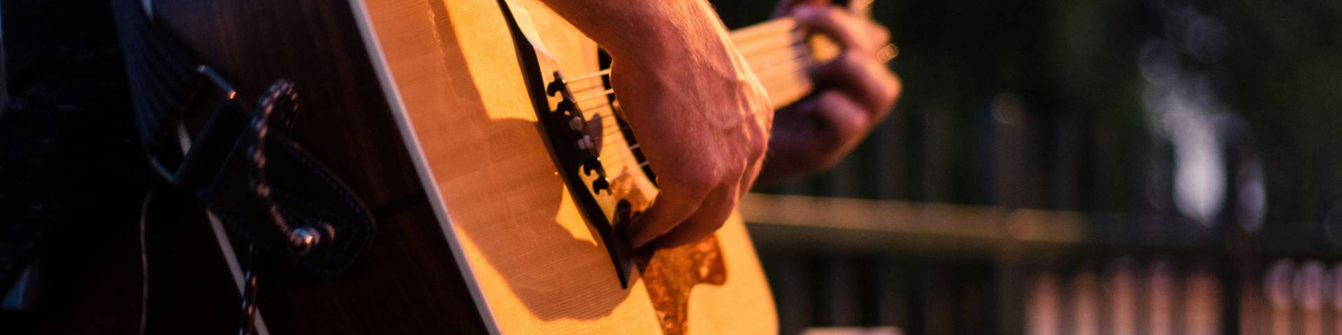 Photograph of a person playing a semi-acoustic guitar