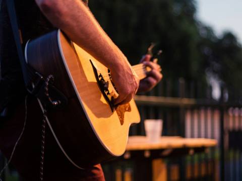 Photograph of a person playing a semi-acoustic guitar