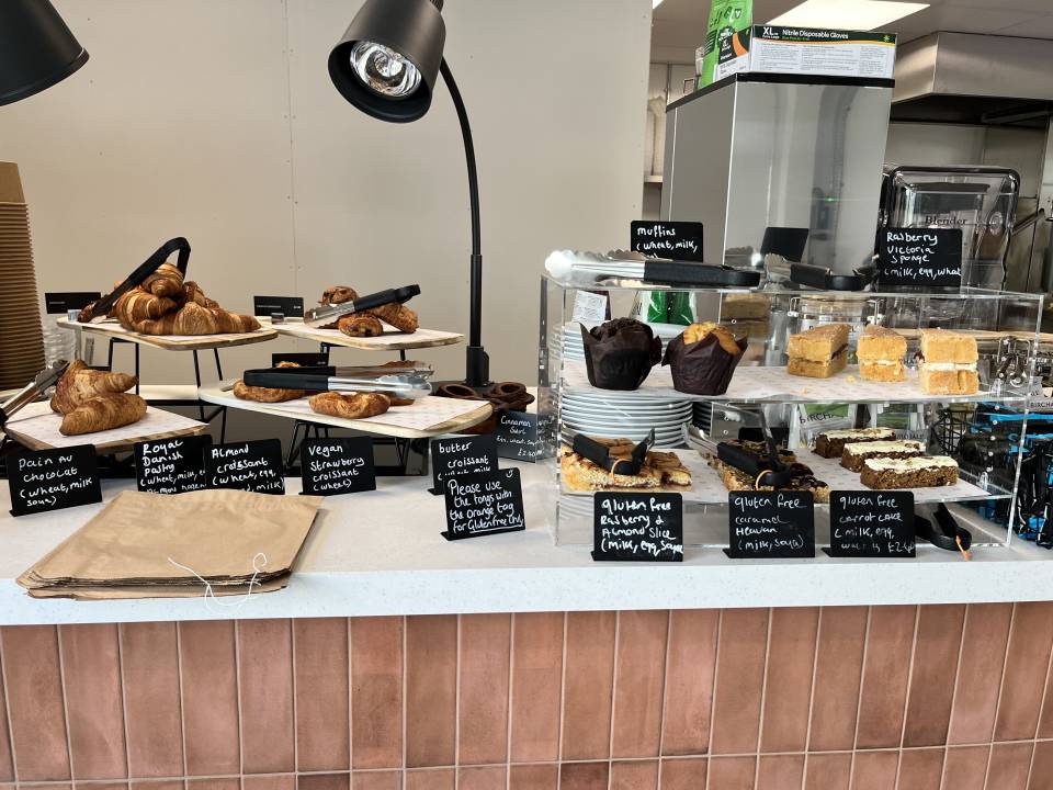 A photograph of a counter with cakes, including gluten free and vegan options.