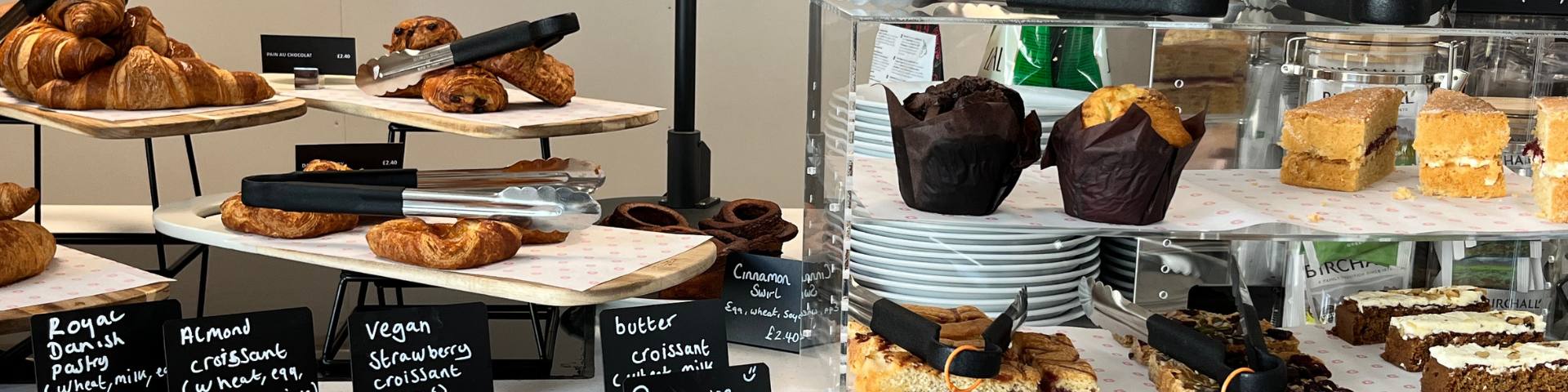 A counter showing cakes for sale. Some are vegan and some gluten free.