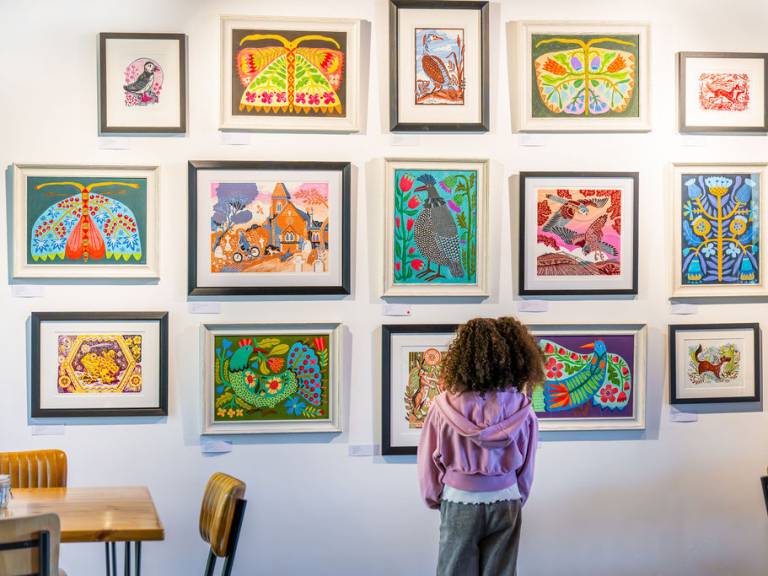 A photograph of a child examining paintings at Stapleford Granary